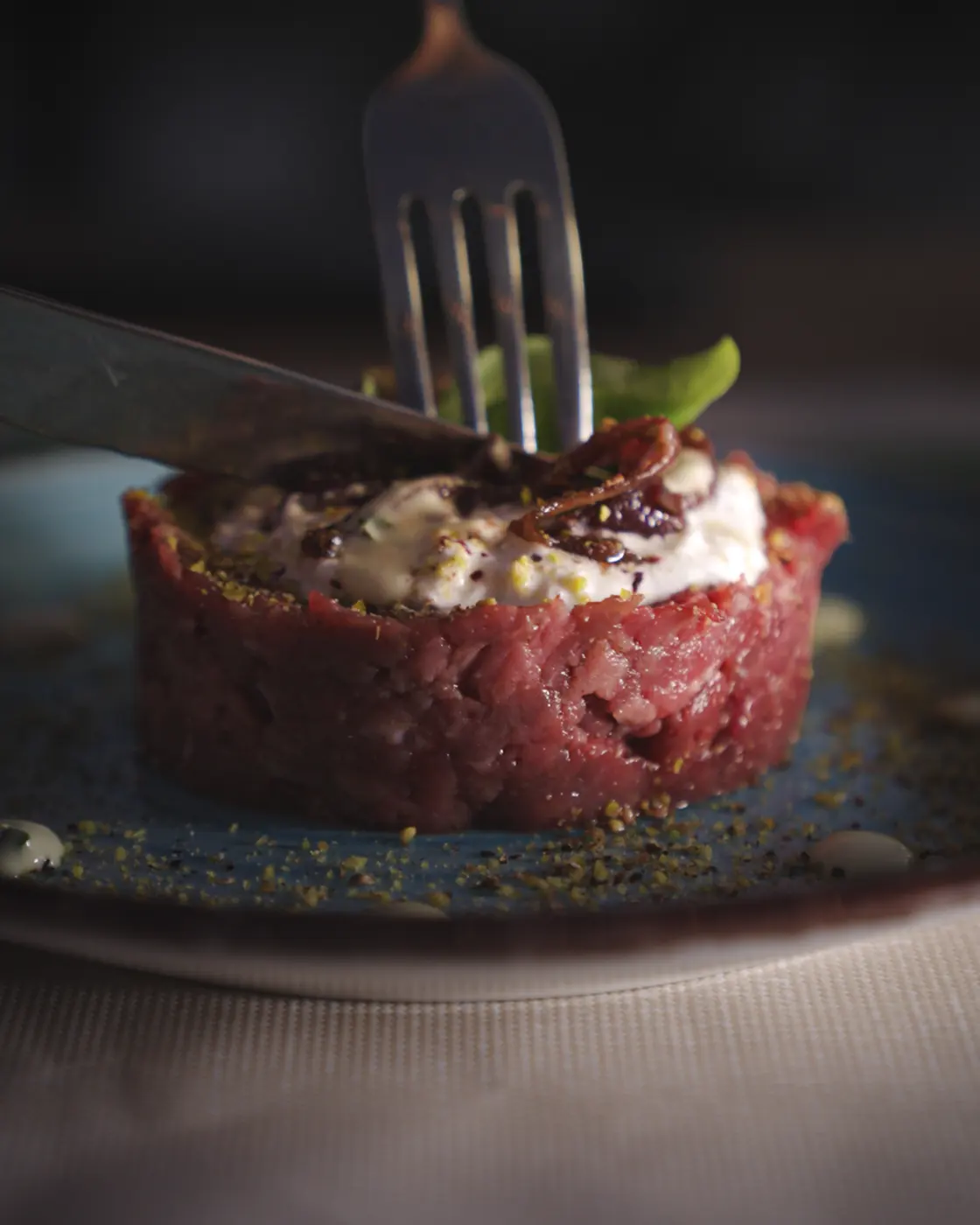 Tartare di scottona battuta al coltello con stracciatella, cipolla caramellata e granella di pistacchio